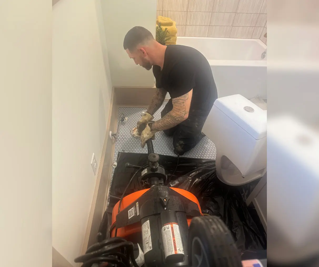 A plumber fixing pipes in a bathroom.
