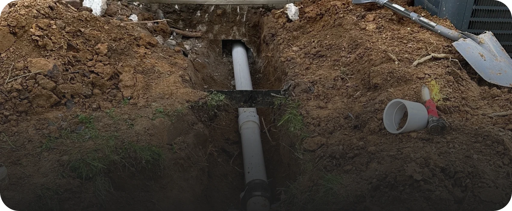 Pipe installation in a dug trench outdoors.