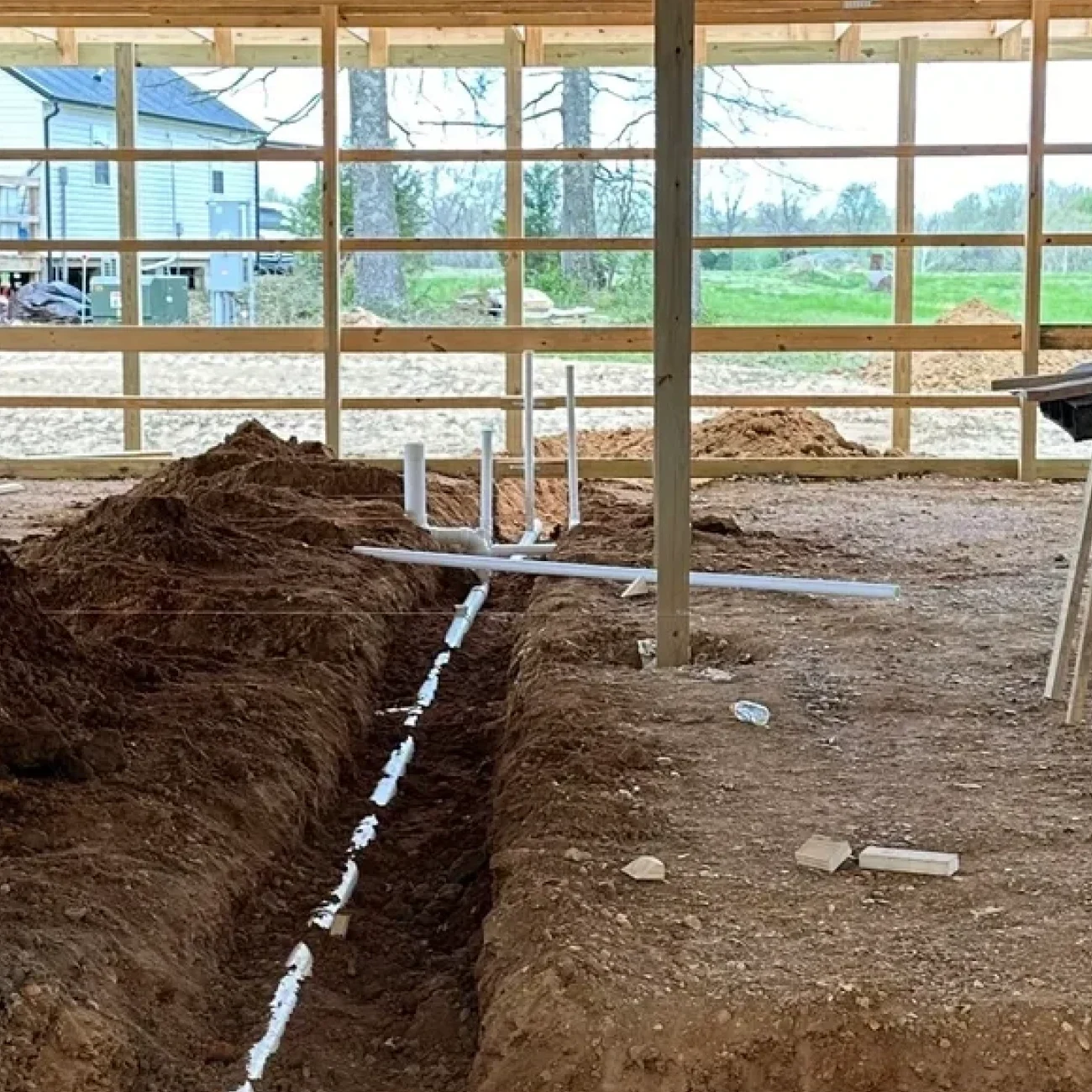 Construction site with building framework and trench.